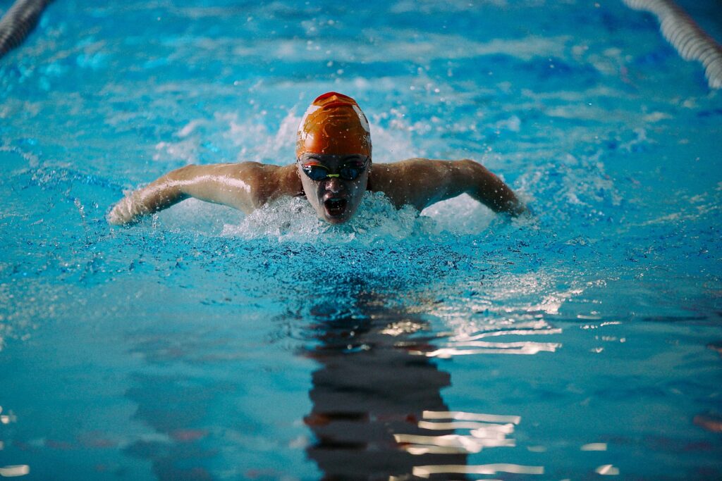 A swimmer racing, with UT Southern swim cap