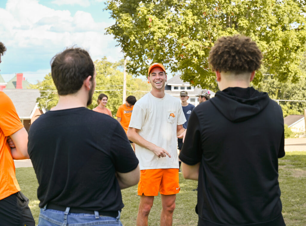 A student smiling and laughing, with others in the foreground