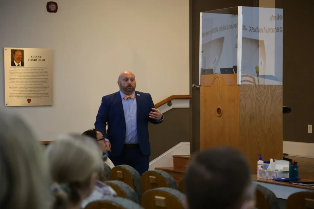 A man speaking to a crowded room