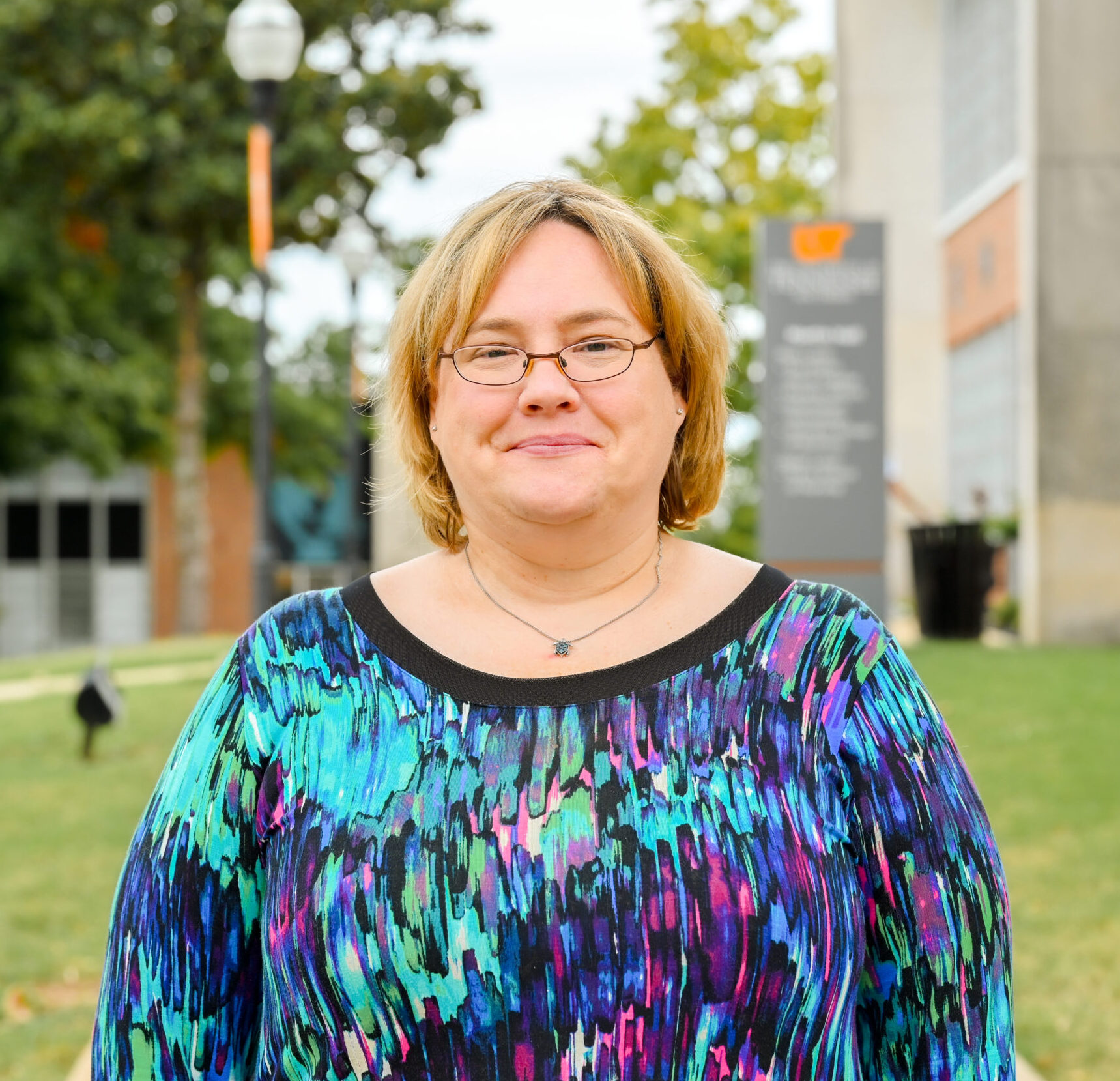 Individual headshot photo with the campus green in the distance