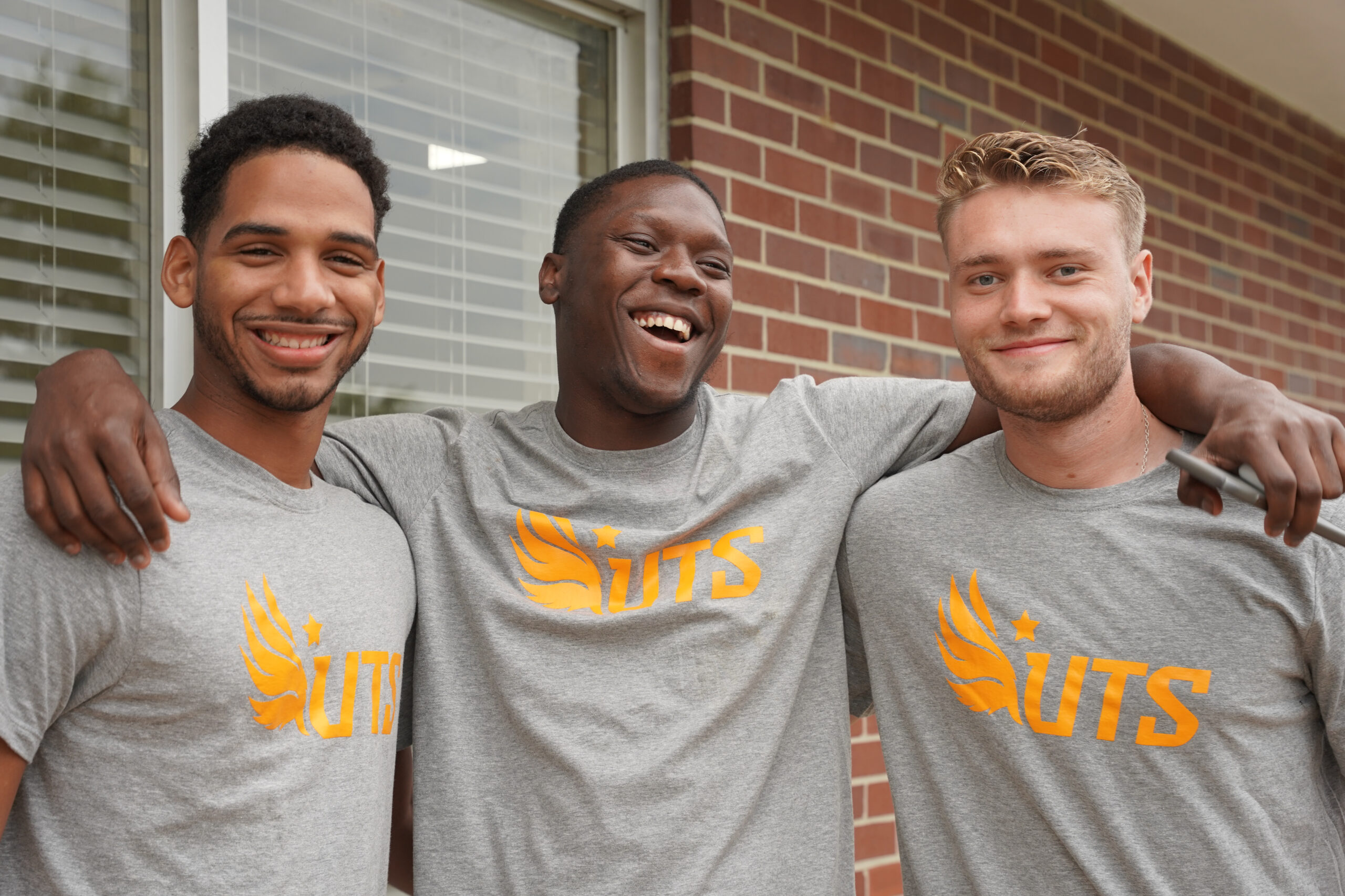 Three students smiling and laughing