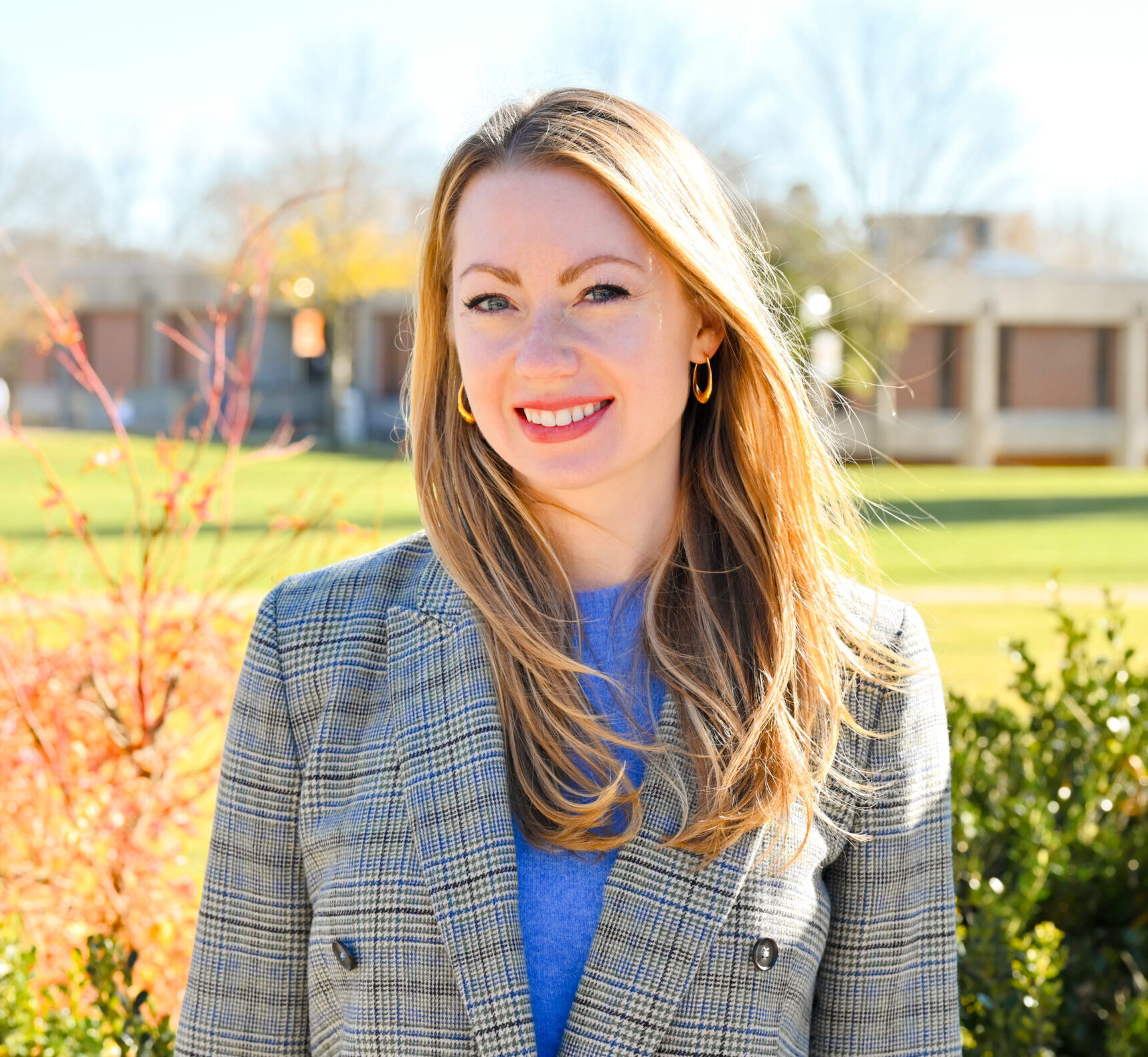 Professor Jessica Conrad posing and smiling for a photo on the campus green