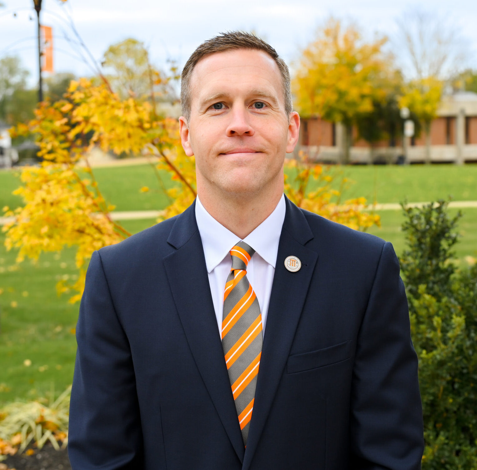 Provost and Vice Chancellor for Academic Affairs posing for a headshot on the campus green