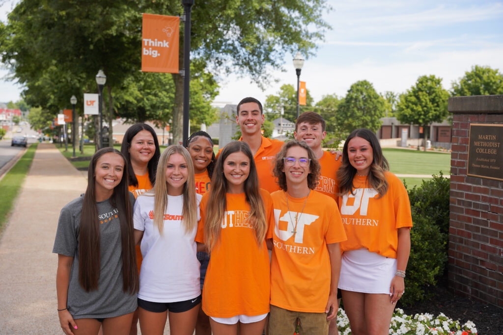 A group photo of students in orange