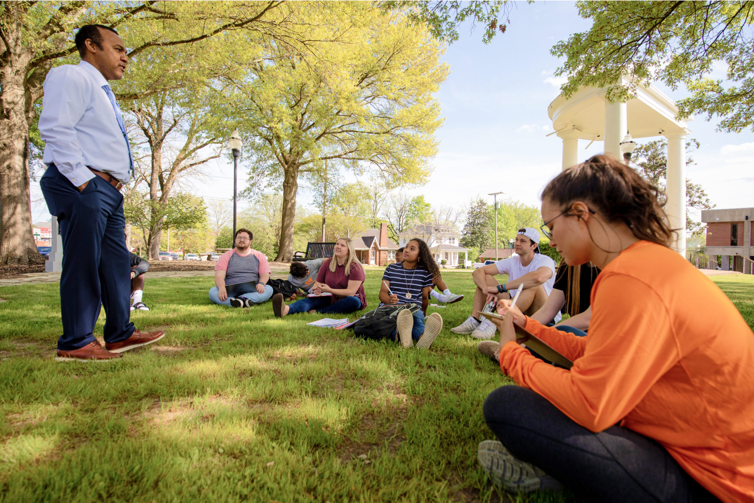 A professor lecturing students on the lawn