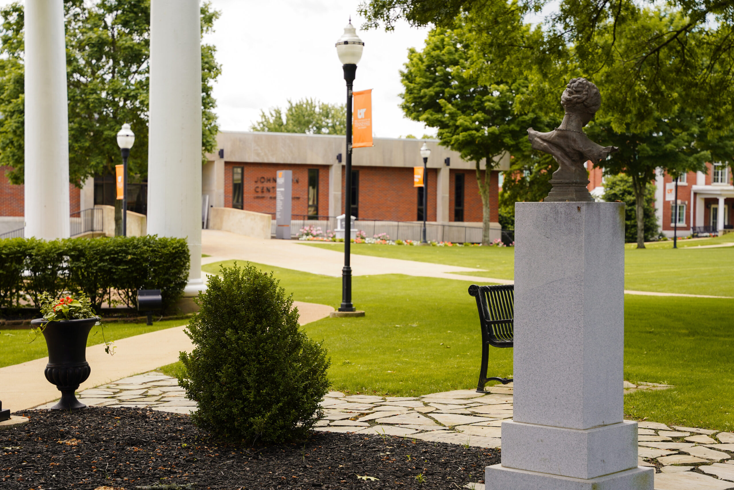 Campus greenway with the columns in the background with a pole light and banner.