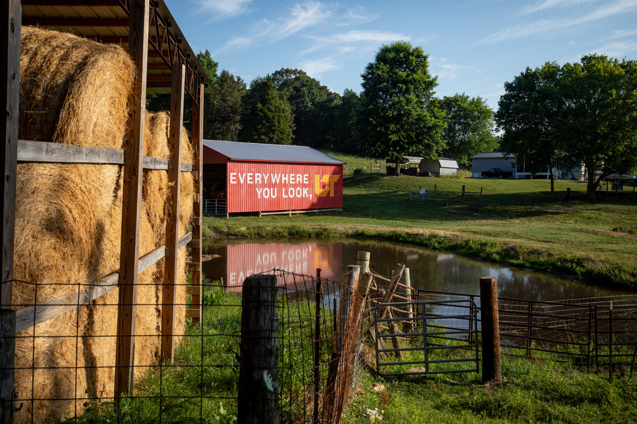 Everywhere you look UT painted on a red barn with hay in the foreground