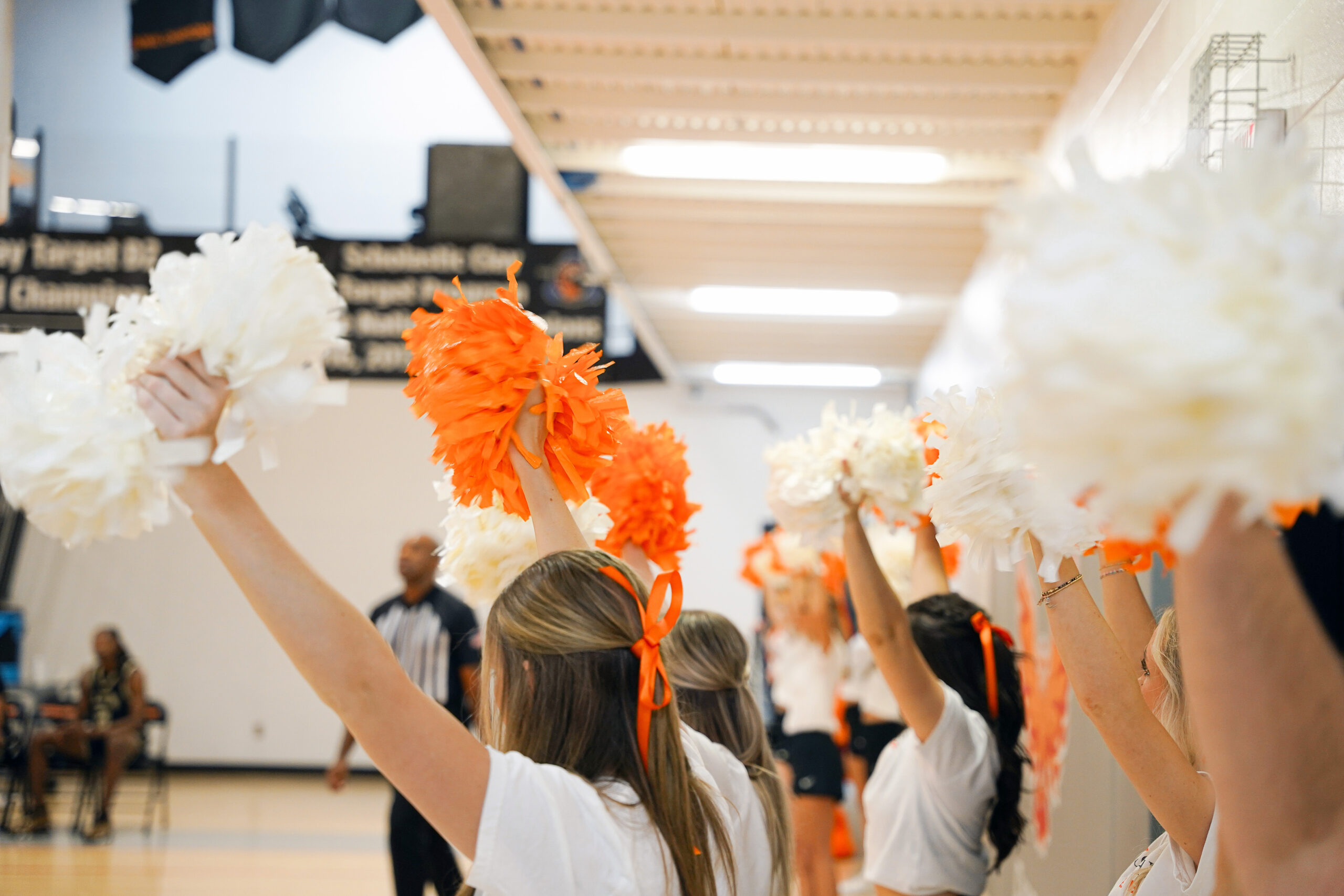 UT Southern Cheerleaders with their arms raised cheering on the sidelines.