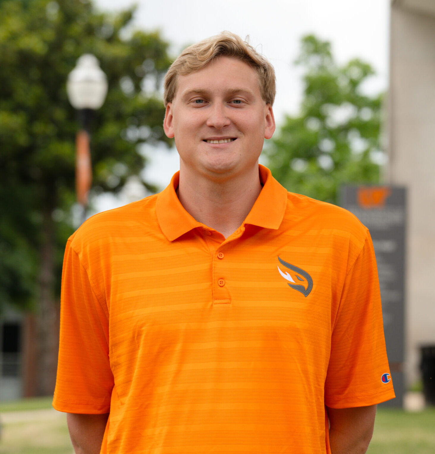 Luke Moeller, Men's Basketball Assistant Coach Posing on the campus green and smiling